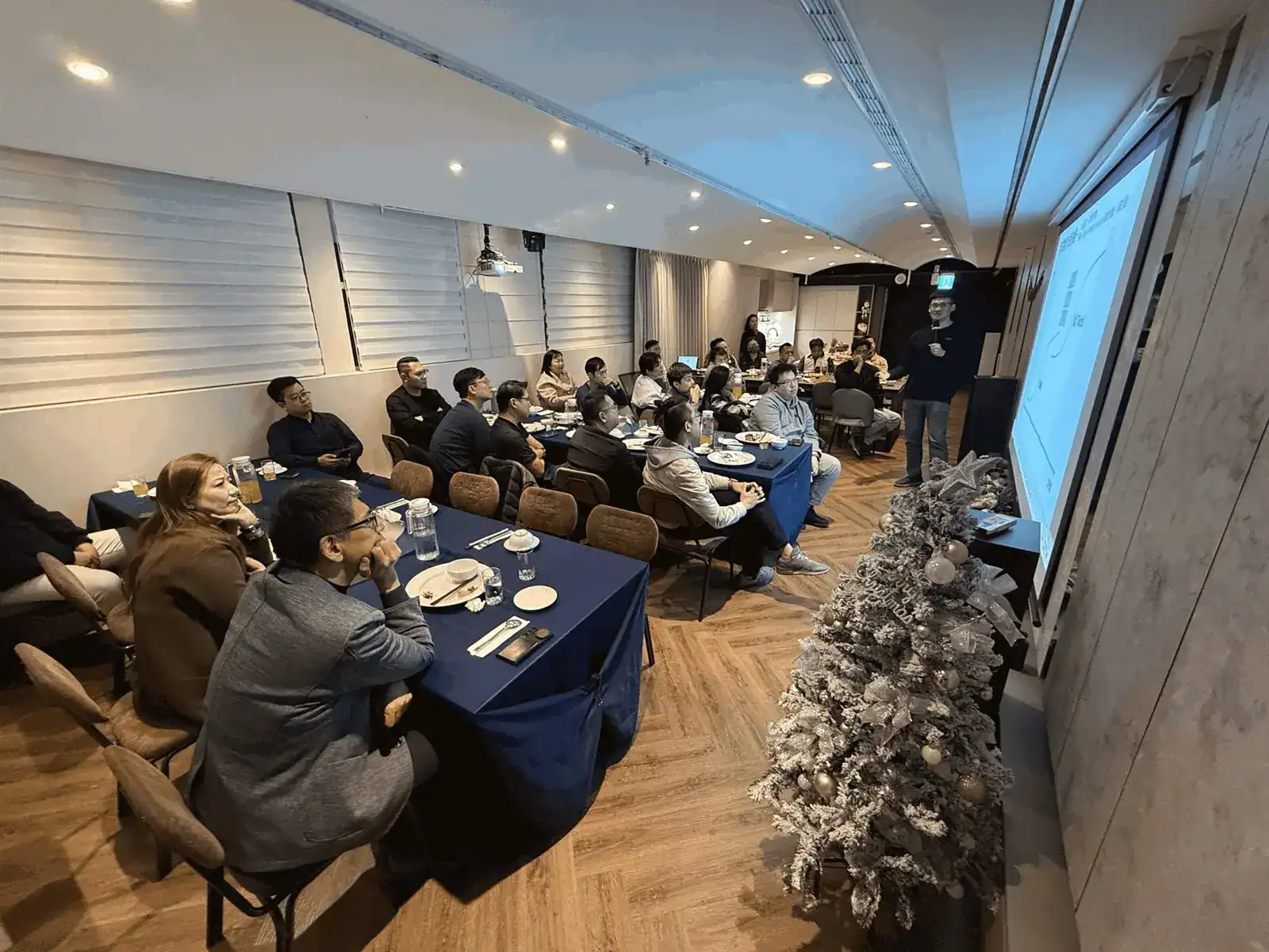 萬聚所包場空間內企業說明會實況，投影簡報與圍桌用餐同時進行