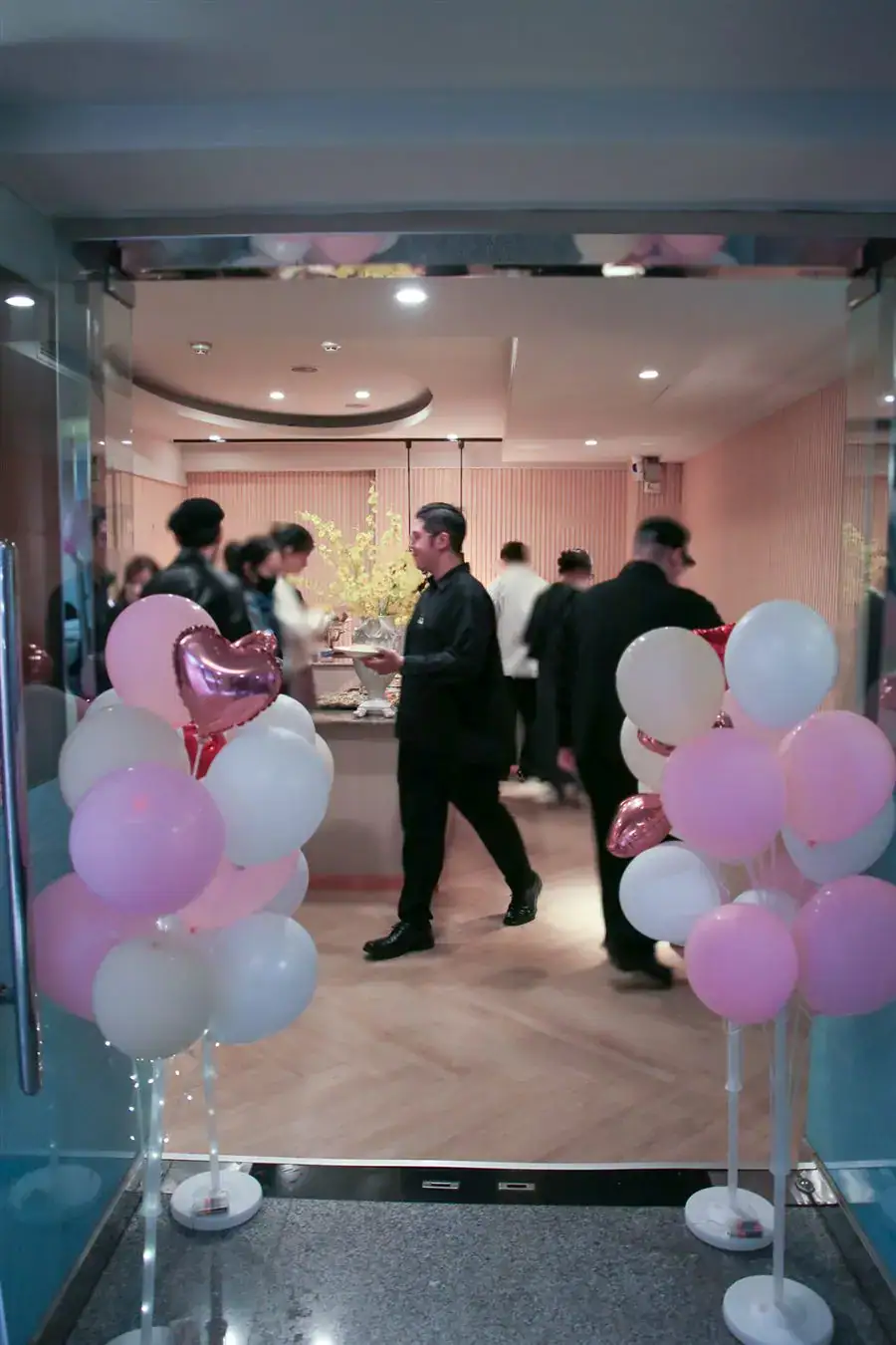 萬聚所中清館婚禮入口玻璃門兩側氣球柱，門內賓客在 Buffet 區取餐