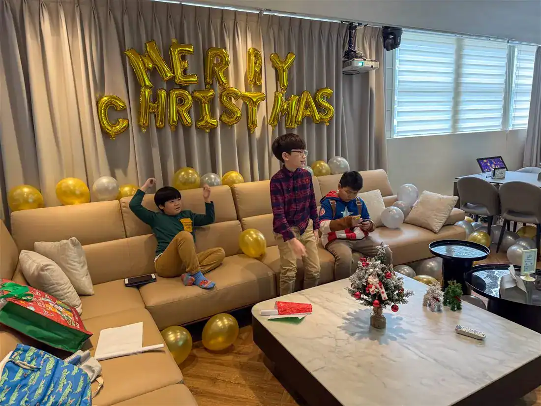 萬聚所勤美館 VVIP 包廂聖誕親子派對：布簾上掛金色 MERRY CHRISTMAS 氣球字，茶几上擺小聖誕樹