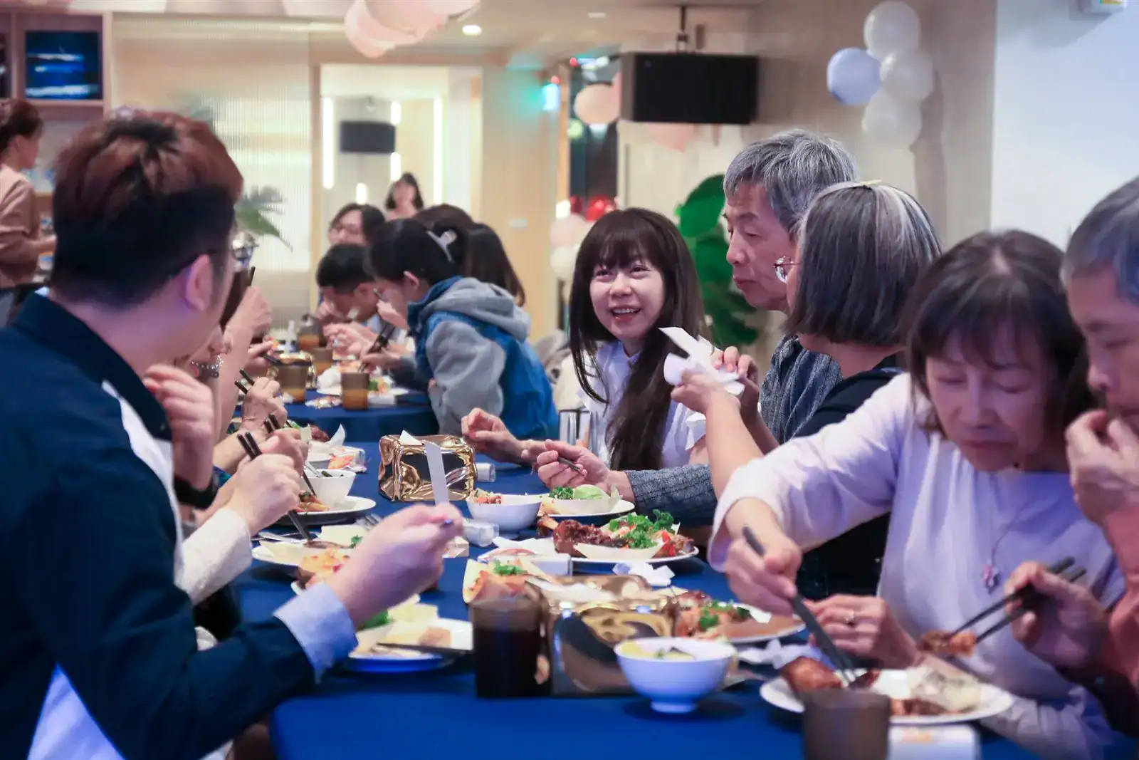 婚禮派對中清館長輩坐長桌一般餐椅用餐，深藍桌布